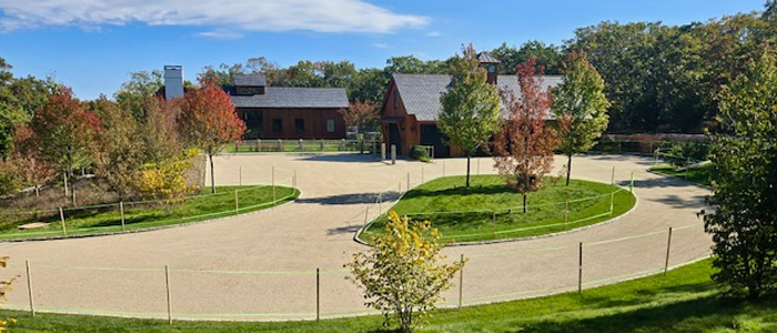 A beautifully designed Macadam driveway at a 100-acre Arabian horse farm on Martha’s Vineyard, surrounded by lush landscaping and a refined estate.