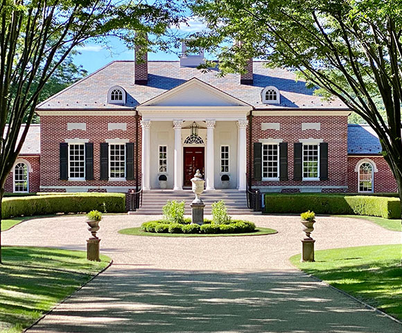 A grand brick mansion with a Chipseal driveway, set amidst trees in Old Saybrook, Connecticut.