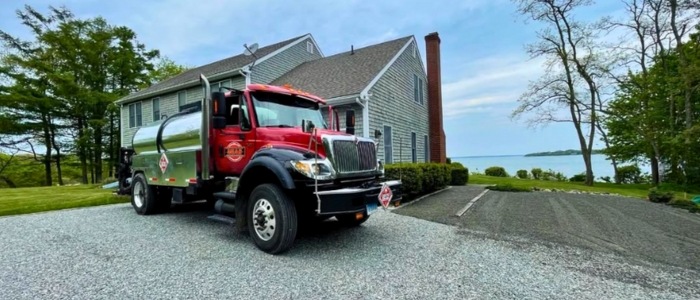 A red truck parked in front of a house, illustrating a scene related to chip seal versus asphalt installation.