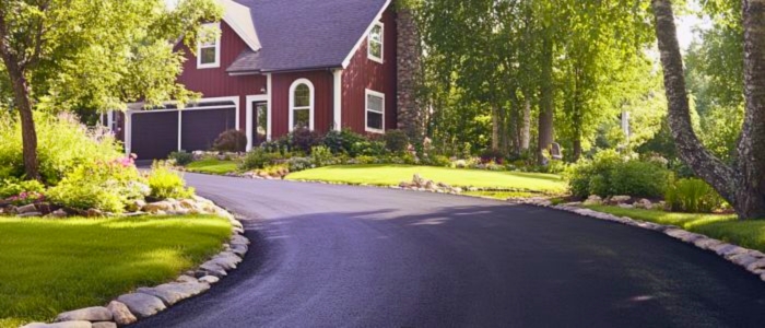 A red house beside a tree-lined driveway, highlighting the benefits of an eco-friendly driveway design.