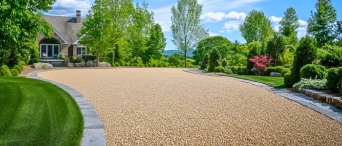 Eco-friendly gravel driveway surrounded by lush lawn and trees, emphasizing environmental sustainability.