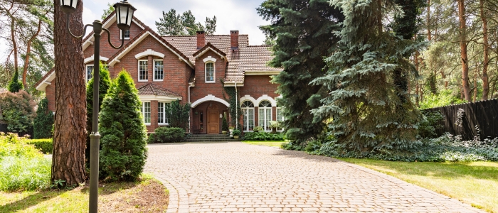 A spacious house is accessed via a well-maintained brick driveway, highlighting the longevity of brick materials.