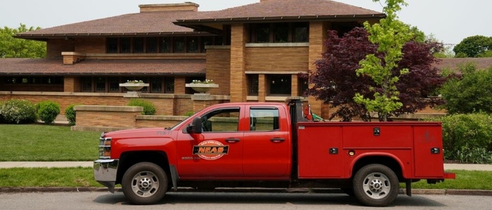 A red truck is parked outside a house, highlighting the oil and stone driveway rejuvenation at Martin House.