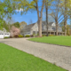 Chip seal driveway in Fairfield CT leading to a home with mature trees and detached garage.