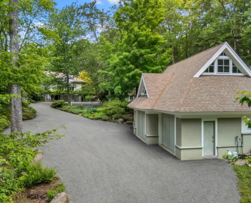 Old Lyme CT chip seal driveway winding through wooded landscaping to a detached garage and residence